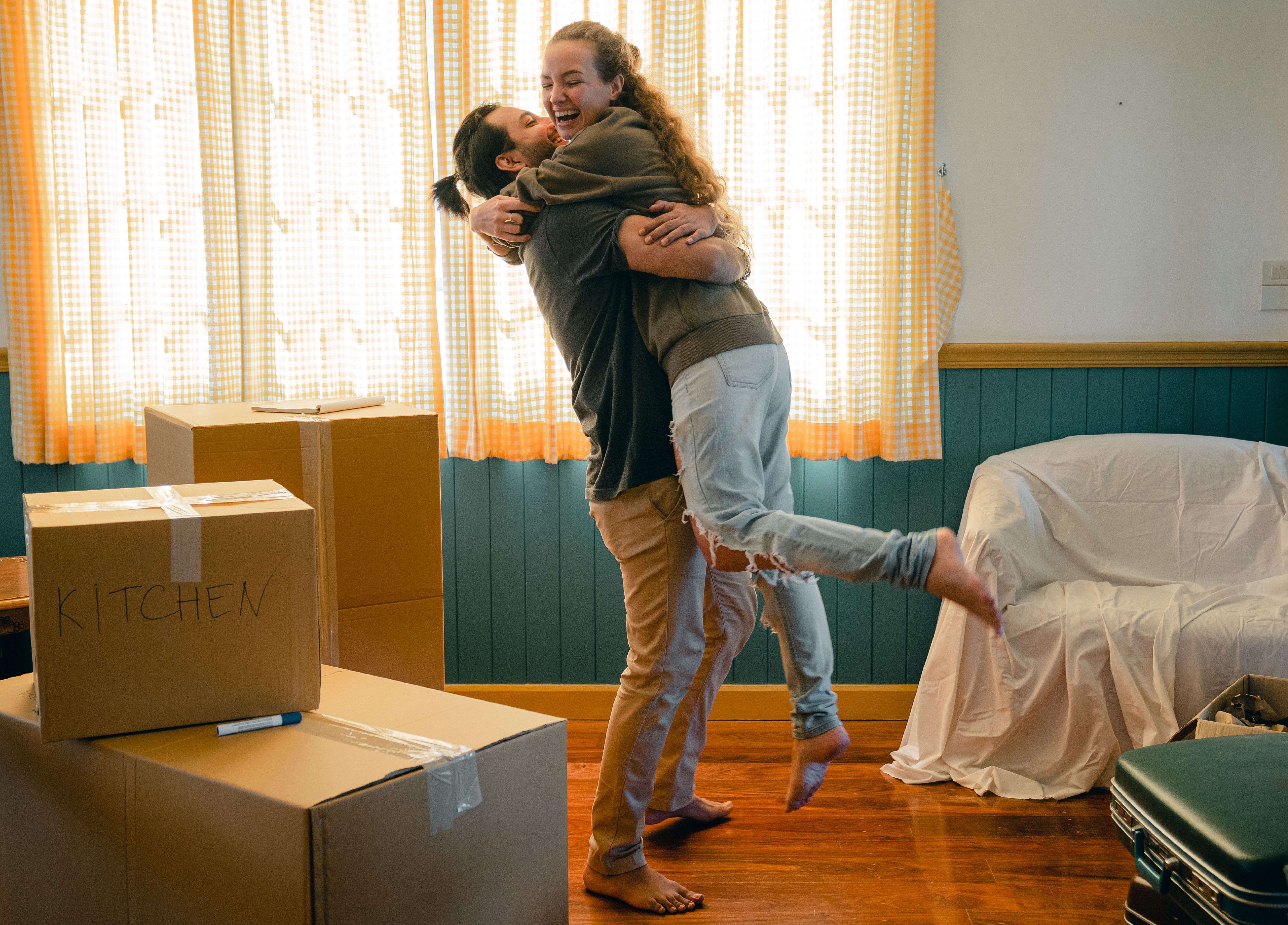 A couple celebrating among moving boxes in their new home